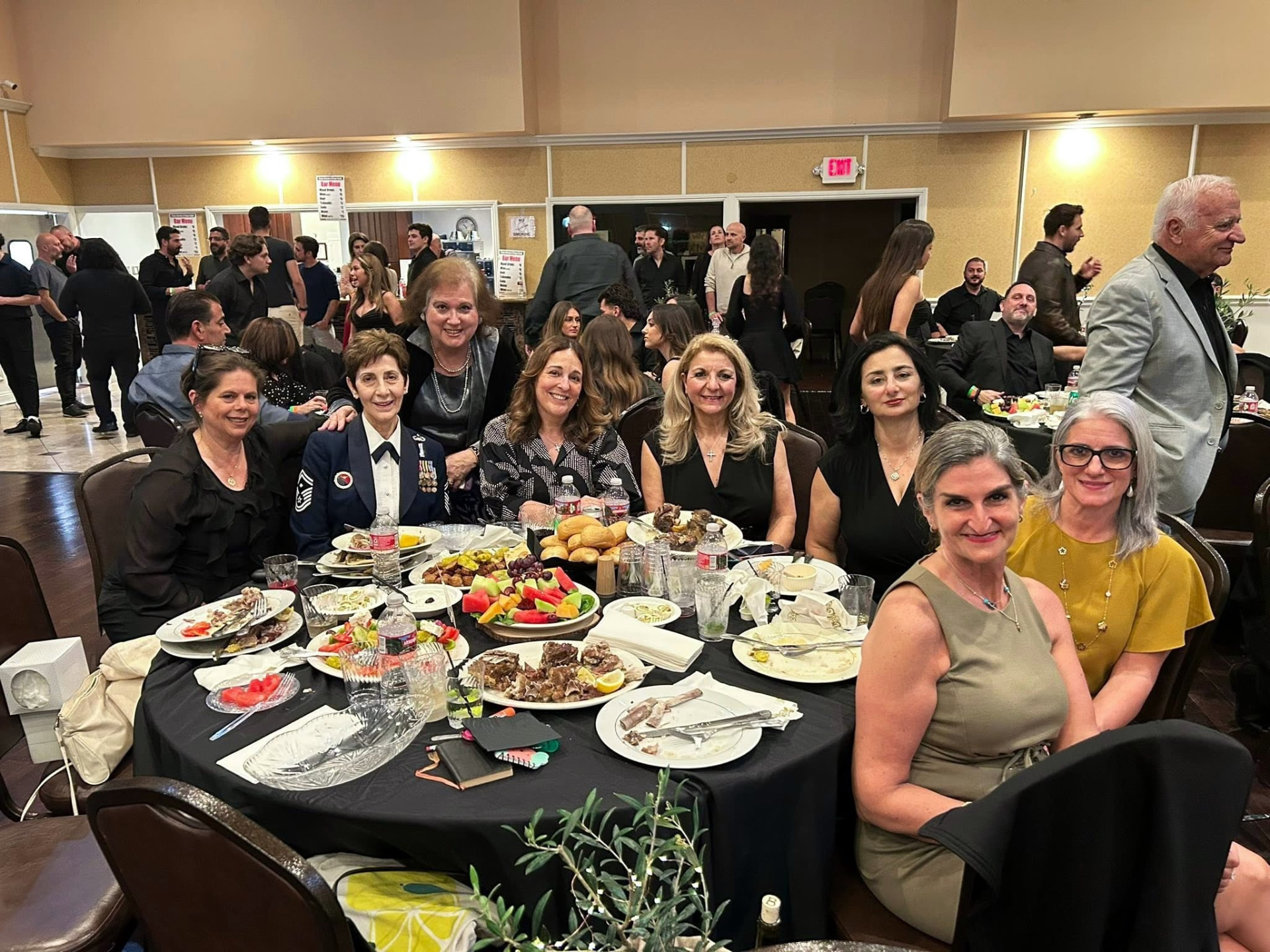 Members posing together at a banquet table laden with food